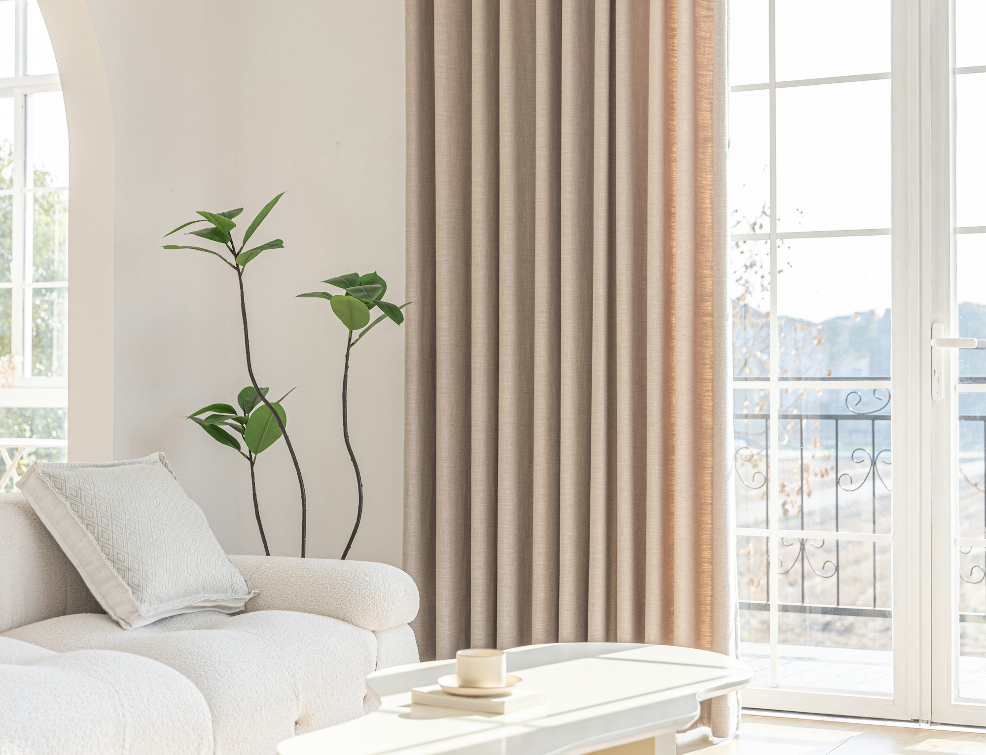 Close detail of tailored pleated drapery beside a sunlit balcony door