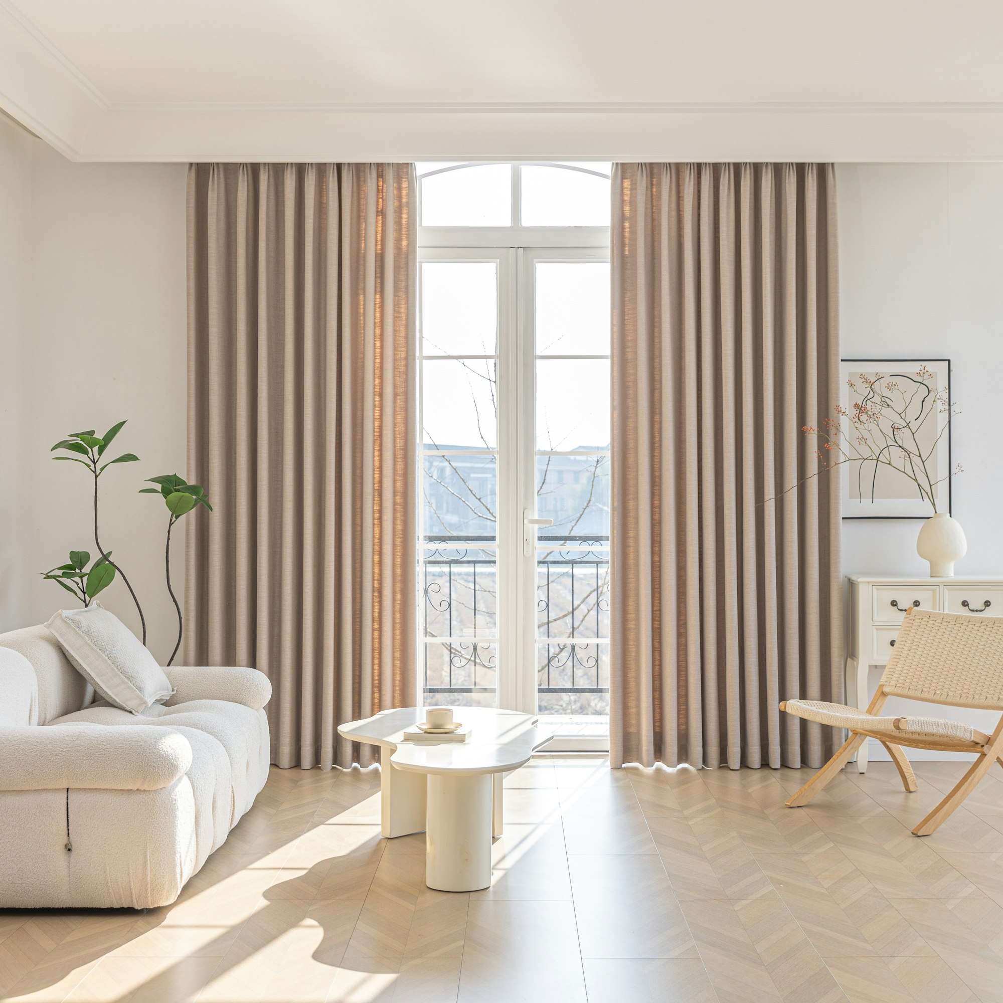 Floor-to-ceiling taupe drapery framing a balcony door in a bright living room